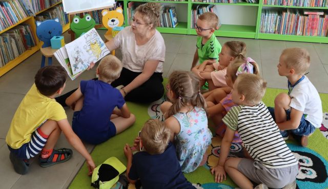 bibliotekarka pokazuje dzieciom książkę