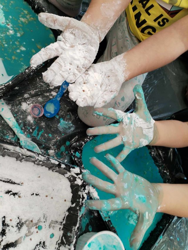 sensoryczne zabawy, dłoń dziecka umazana w białej masie
