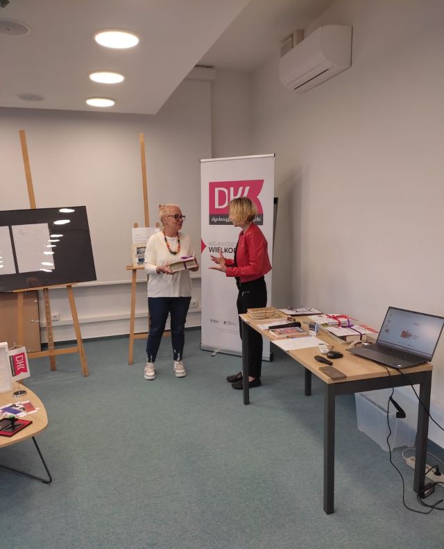 czytelniczka odbiera nagrody książkowe od kobiety