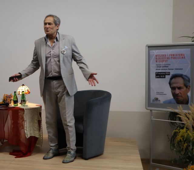 aktor stoi z rozłożonymi rękoma