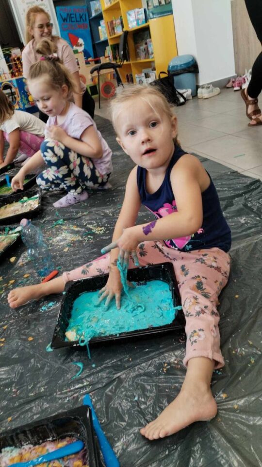 dziewczynka z dłonią w masie niebieskiej