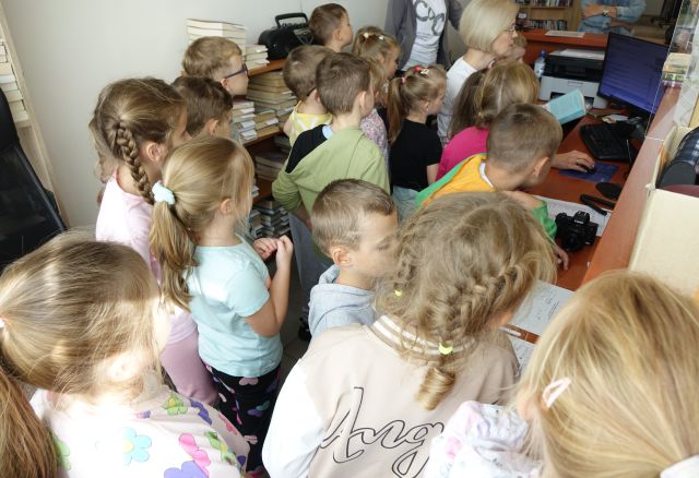 przedszkolaki zgromadzone wokół biurka bibliotekarki
