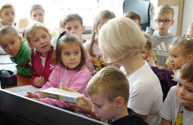 przedszkolaki zgromadzone wokół biurka bibliotekarki