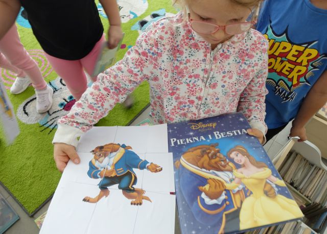 dziewczynka pokazuje puzel i taką samą książkę