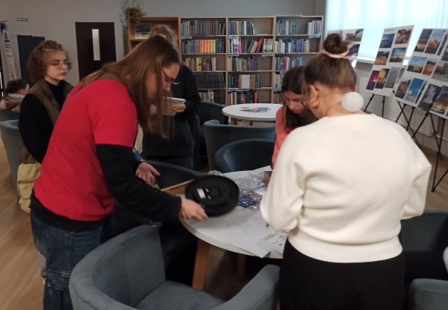 chłopak i 3 dziewczyny wkładają baterię do zegarka