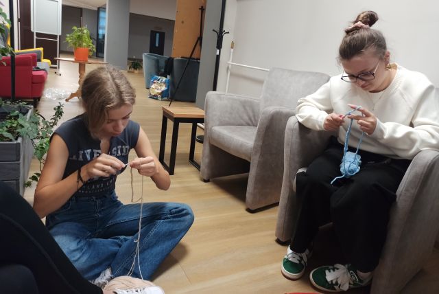 dwie dziewczyny siedząc na podłodze szydełkują