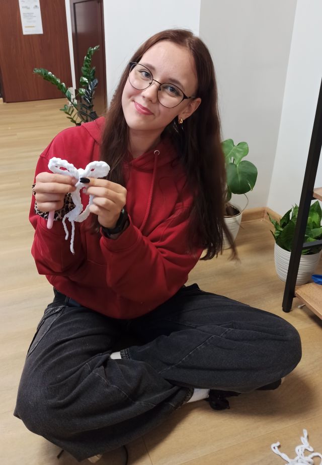 dziewczyna pokazuje swoją szydełkową pracę