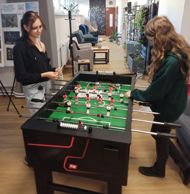 2 dziewczyny montują piłkarzyki na stole do dry w piłkarzyki