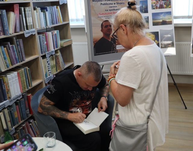 autor podpisujący książkę czytelniczce