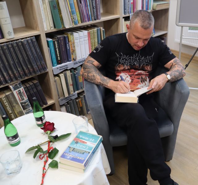 autor podpisuje książkę