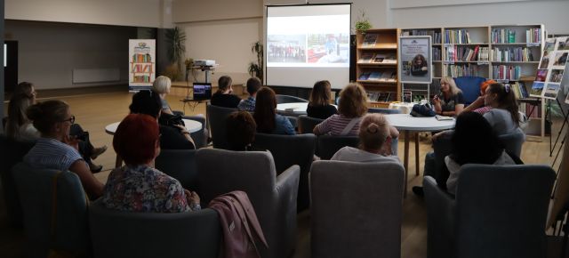 uczestnicy spotkania autorskiego siedzą na fotelach