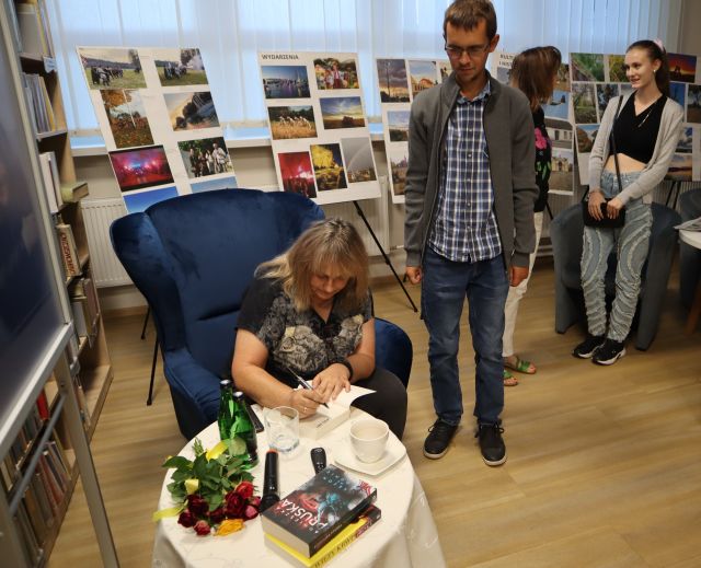 autorka podpisuje książkę uczestnikom spotkania