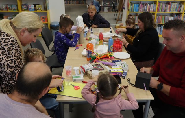 mali i dorośli uczestnicy warsztatów robią roboty