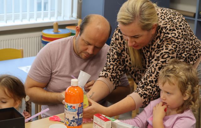 dziewczynka i jej rodzice robią roboty