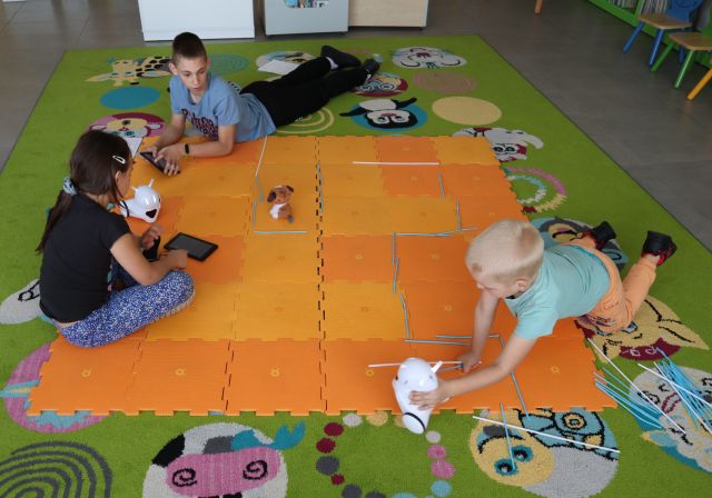 3 dzieci steruje przy użyciu tabletów robotami Photon