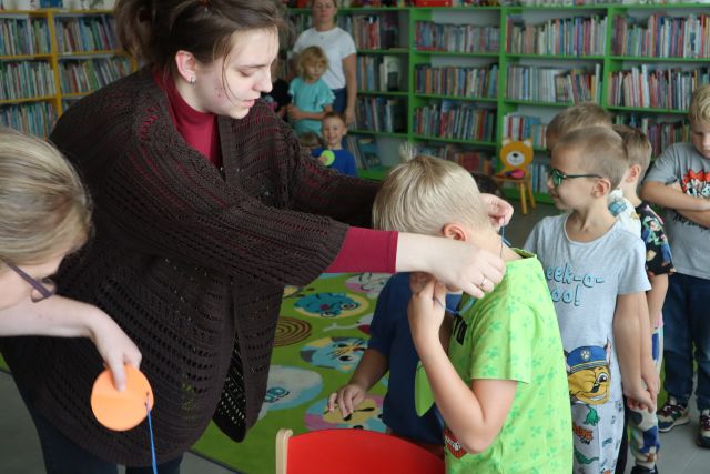 bibliotekarka zakłada chłopcu medal