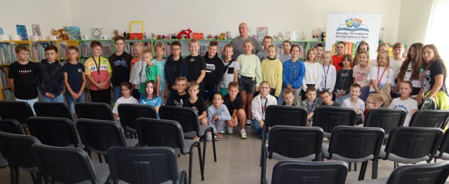 dzieci pozują do zdjęcia z autorem