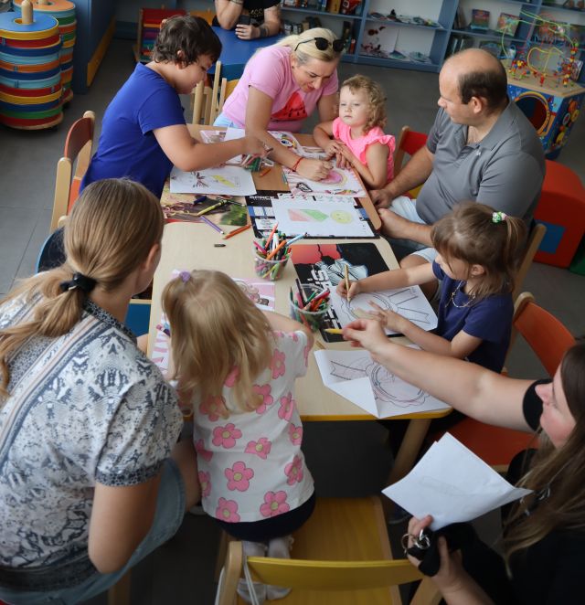 uczestnicy warsztatów pracujący przy stolikach