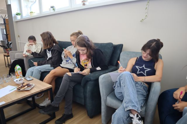 młodzież notuje siedząc na wygodnych fotelach