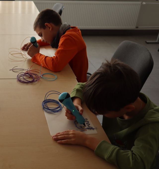 dwóch chłopców rysuje długopisem 3d