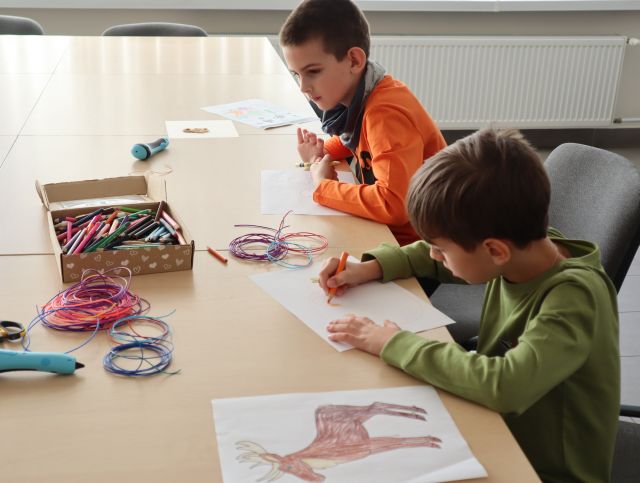 chłopcy rysują na kartkach