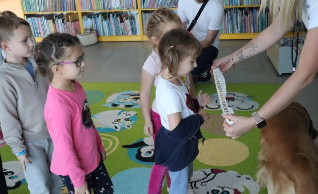 dzieci stoją w kolejce do pani z naklejkami