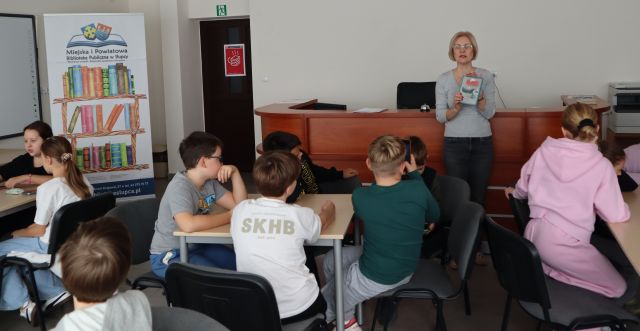 bibliotekarka pokazuje dzieciom książkę