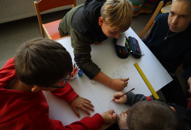 dzieci rysują na dużej kartce