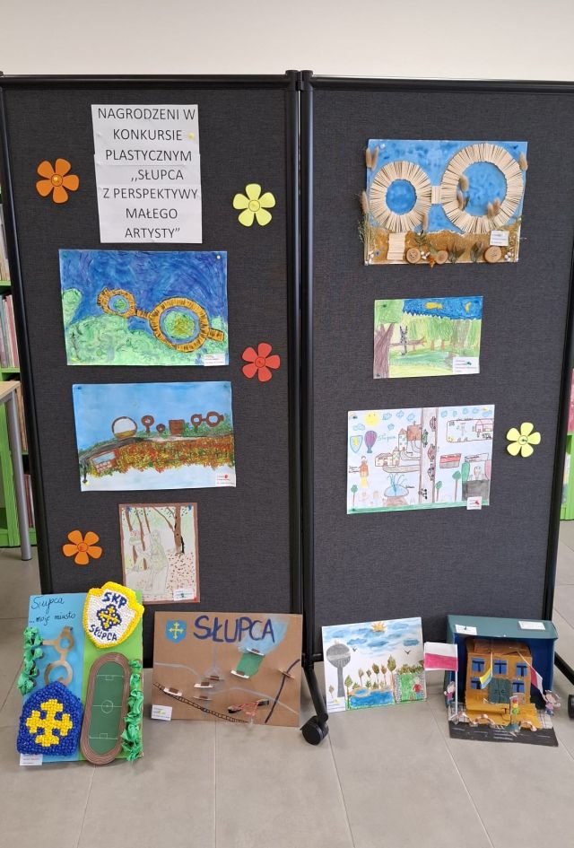na czarnej tablicy wywieszone prace plastyczne przedstawiające Słupcę