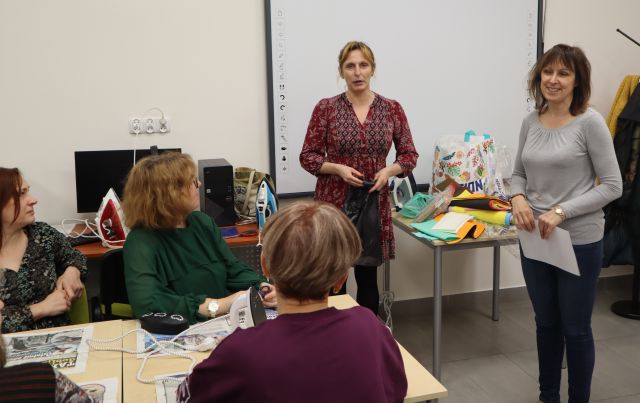 dwie kobiety stoja przed siedzącymi uczestnikami warsztatów