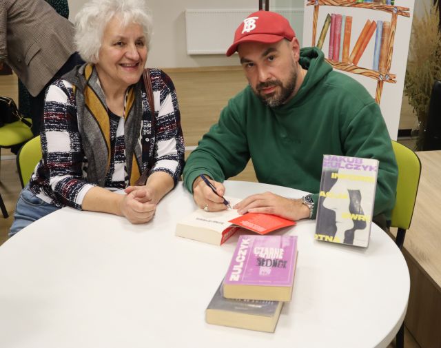 autor podpisuje książkę uczestniczce spotkania