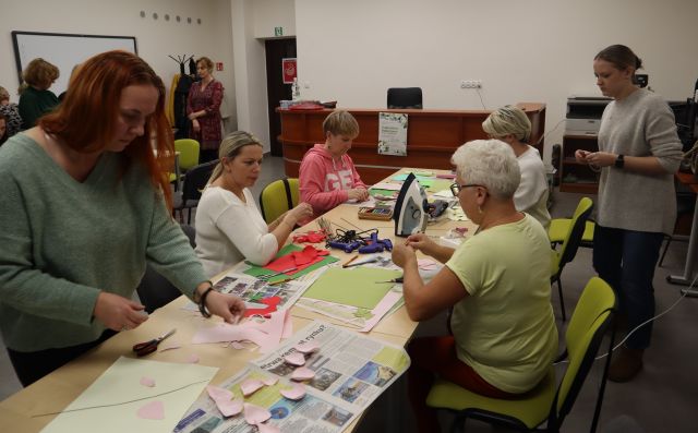 kobiety wycinają kwiaty z materiałów