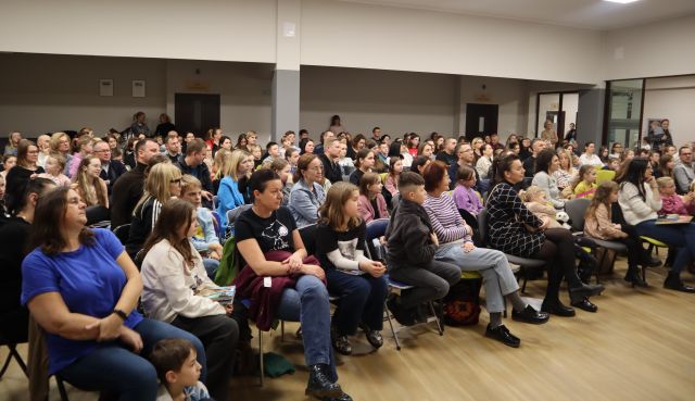 około 300 osób siedzi na krzesłach