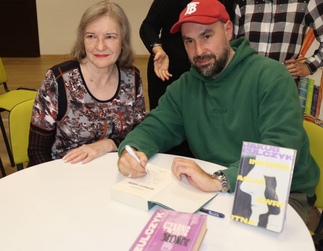 autor podpisuje książkę uczestniczce spotkania