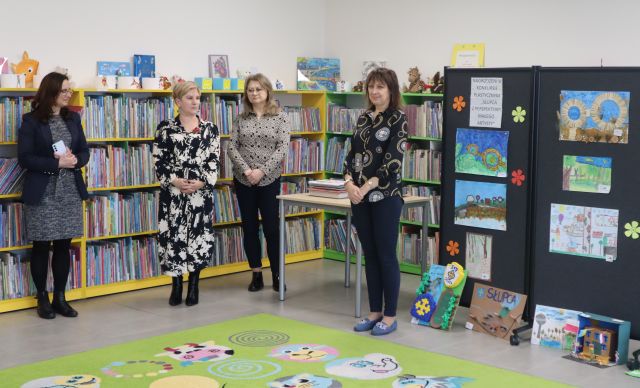 przed regałami z książkami stoją 4 kobiety