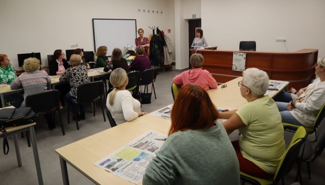 dwie kobiety stoją przed siedzącymi uczestniczkami warsztatów 
