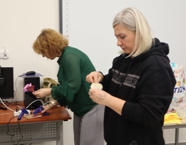 dwie kobiety robią kwiaty z materiałów