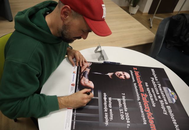 autor podpisuje się na plakacie