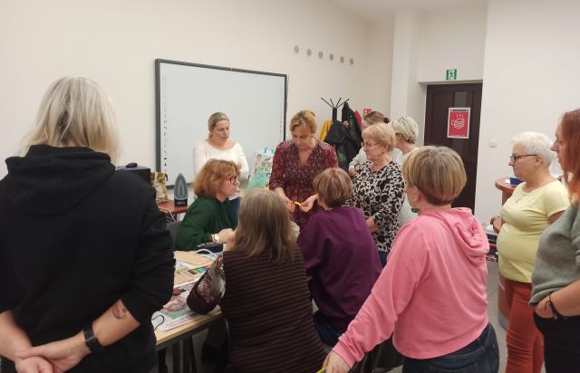 uczestniczki warsztatów stoją przy prowadzącej