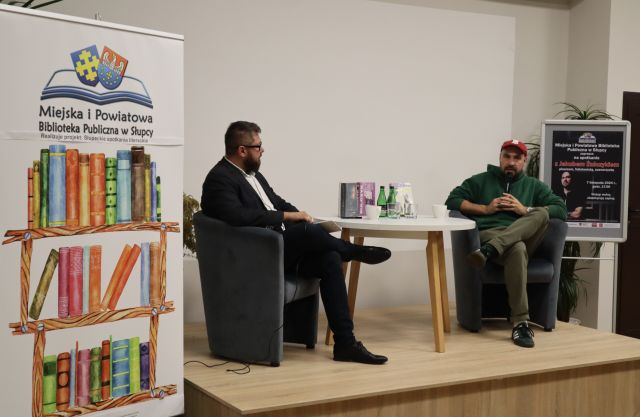 dwóch mężczyzn siedzących na fotelach przy okrągłym stole