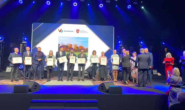 na zdjęciu osobyodbierające nagrody, w tle zdjęcie z logo konkursu