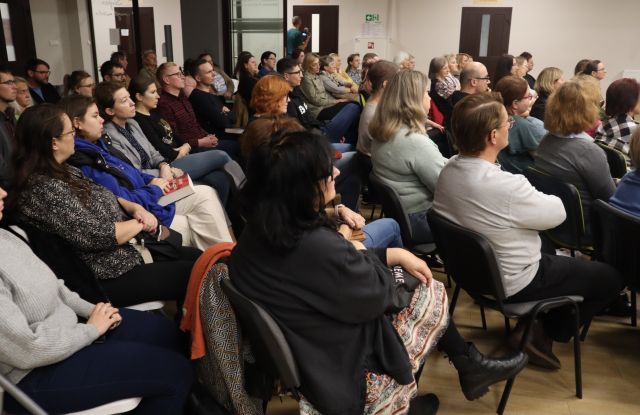 siedzący na krzesłach uczestnicy spotkania