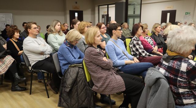 siedzący na krzesłach uczestnicy spotkania
