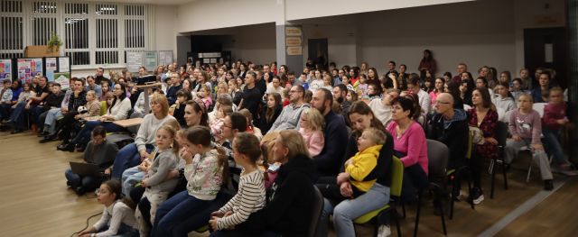 prawie 300 osób siedzi na krzesłach