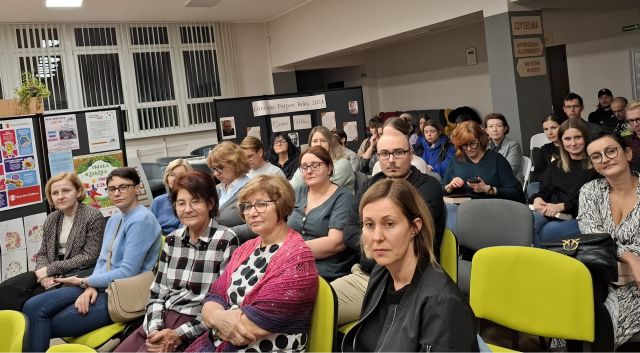 siedzący na krzesłach uczestnicy spotkania