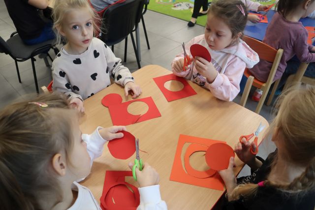 4 przedszkolaków wycina kotyliony z papieru