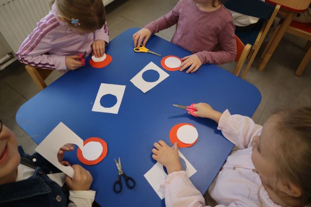 przedszkolaki robią kotyliony z papieru