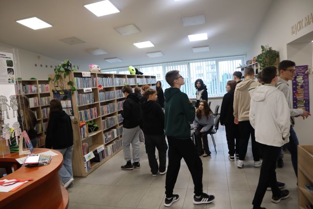 młodzież spaceruje po pomieszczeniu z księgozbiorem dla młodzieży