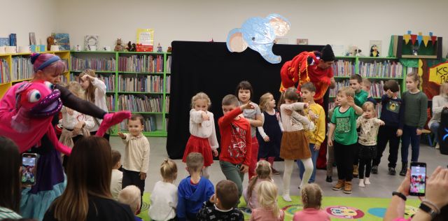 dzieci z aktorami przebranymi za mappety stoją z wyciągniętymi do przodu rękami