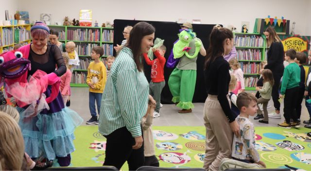 aktorzy przebrani za mappety idą w kółko z dizećmi i rodzicami